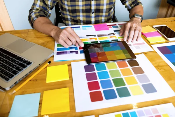 Graphic designers use the tablet to choose colors from the color — Stock Photo, Image