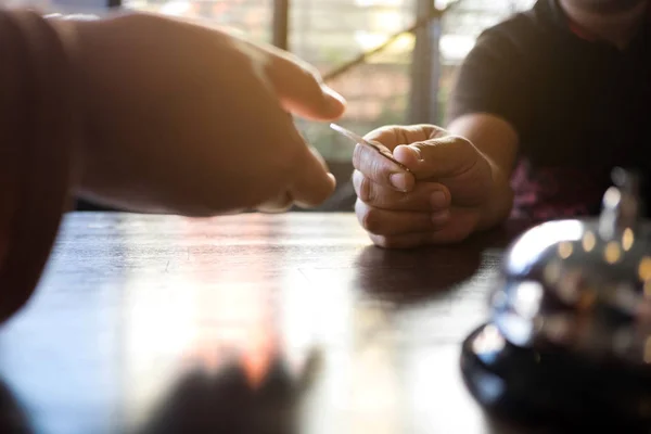 Närbild av hand gäst tar rumsnyckel vid incheckningsdisken av den ho — Stockfoto