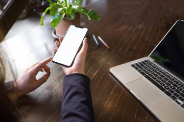 Masaya mobil akıllı telefon kullanarak bir kadının yakın çekim.