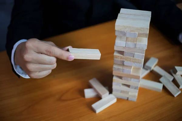 Businessmen picking wood blocks to fill the missing dominoes. Gr — Stock Photo, Image