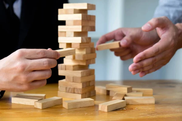 Empresarios recogiendo bloques de madera para llenar los bloques de madera que faltan — Foto de Stock