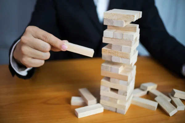 Businessmen picking wood blocks to fill the missing dominoes. Gr — Stock Photo, Image
