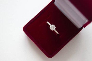 Beyaz zemin üzerine kırmızı hediye kutusu içinde güzel parlak Alyans, yakın çekim. İçin hediye ve evlilik teklifi.