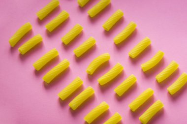 İtalyan gıda kavramı. Makarna Tortiglioni pembe bir arka plan üzerinde
