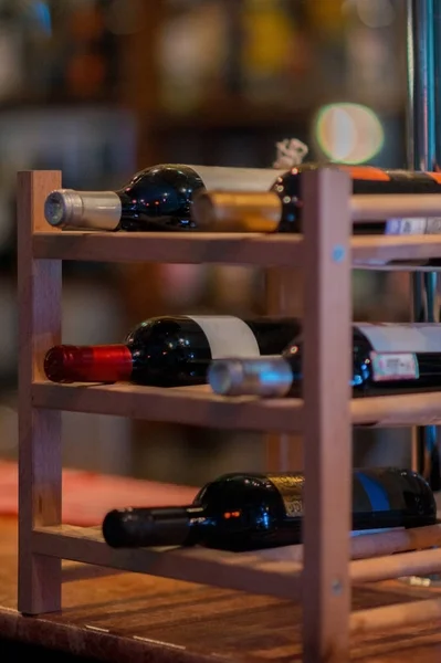 Wine rack with bottles on the bar counter. Vertical orientation. Concept for bars and restaurants
