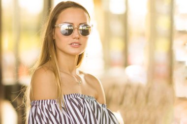 Bir kızın sıcak tonlarda ayna güneş gözlüğü moda portre