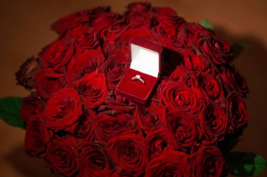 Sevgiliye arka plan üzerinde kırmızı kadife hediye kutusunda değerli taşla güzel alyans önden görünümü. İçin hediye ve evlilik teklifi.