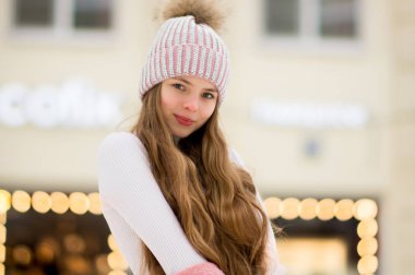 Bir kız bir pembe sıcak ceket ve şapkayla