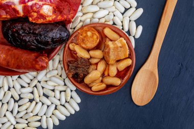 İştah açıcı kaşık yemek. Sonbahar, kış ve bütün bir yıl için lezzetli. Asturyan fabada, tipik çanak Asturias (İspanya). Güveç fasulye (beyaz fasulye) chorizo, pastırma, siyah puding, pastırma, soğan, sarımsak, maydanoz ve tuz ile.