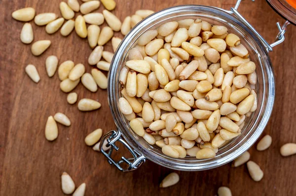 Soyulmuş çam fıstığı. Havadan görünümü (yukarıdan, üstten görünüm). Ön plan (yakın çekim). Ahşap arka plan rustik, doğal ve ev yapımı bir görünüm.