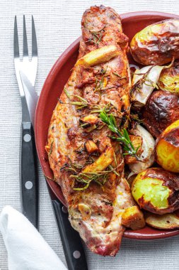 Baharat ve patates (kara biber, zeytin yağı, sarımsak, taze biberiye, tuz) ile lezzetli ve iştah açıcı kavrulmuş domuz eti bonfile. Üstten görünüm.