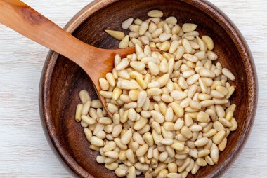 Soyulmuş çam fıstığı. Havadan görünümü (yukarıdan, üstten görünüm). Ön plan (yakın çekim). Ahşap arka plan rustik, doğal ve ev yapımı bir görünüm.