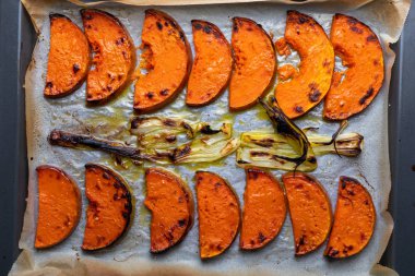 İştah açıcı kavrulmuş kabak dilimleri Pişirme tepsisi üzerinde. Soğan ile.