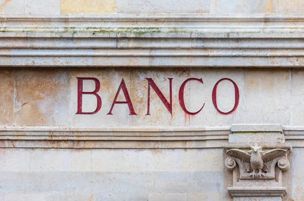 Palabra bancaria en español esculpida en piedra y color rojo. Mirada vieja —  Fotos de Stock
