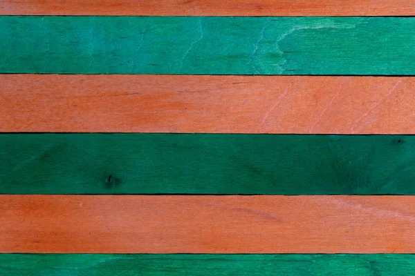 Vacker textur av naturligt trä lameller av orange och gröna färger. Naturliga och åldern utseende. — Stockfoto