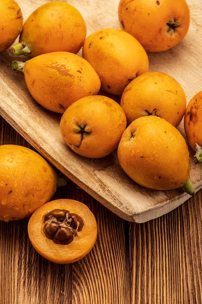 Ahşap arka planda taze loquats (medlars). Rustik ve sağlıklı bir görünüm. Close-up.Top görünümü.