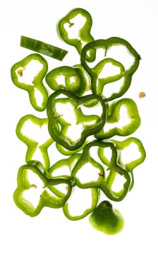 Çok taze yeşil biber dilimleri (su damlaları ile) düşüyor. Beyaz arka planda yalıtılmış.