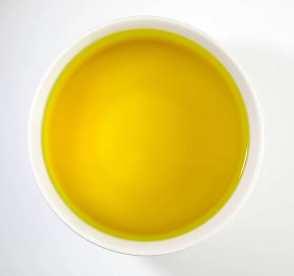 Bowl of extra virgin olive oil. Close-up, with overhead view on white background. — Stock Photo, Image