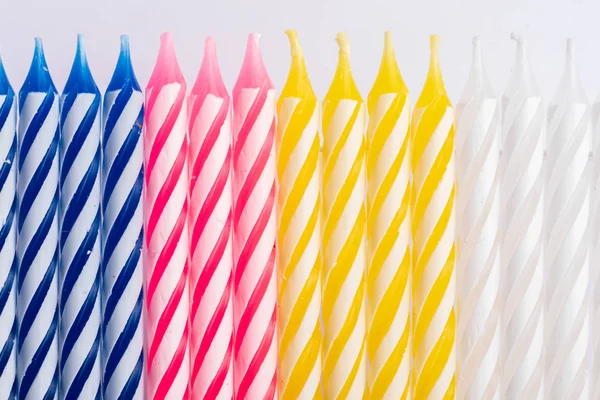 Close-up with birthday candles. Vertical position. Very colorful, with blue, red, yellow and white. For birthday greeting card..