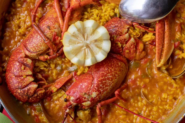 Istakoz, istiridye ve diğer deniz ürünleri ile krempirinç yakın çekim. Paellera sunulan.