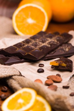 Siyah çikolata ve turuncu. Masada fındıklı çikolata