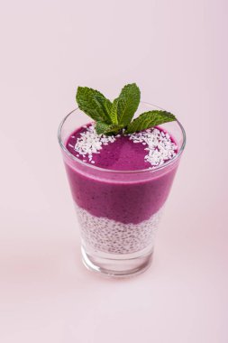 Berry güler yüzlü. Bir bardak beyaz bir arka plan üzerinde mor puding.