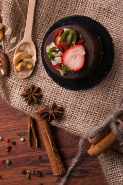 Kek çilek ve fındık masanın üzerinde. Tatlı meyve ve tarçın ile.