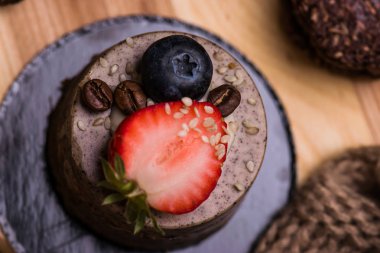 Çikolata tatlı çilek ve yaban mersini yakın çekim ile. Pasta ve bisküvi masada.