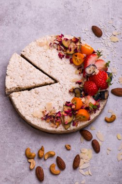 Meyve, çilek ve badem hafif bir arka plan üzerinde beyaz pasta. Çocuk oyuncağı.