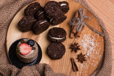 Çerezleri kapatmak. Çikolata kurabiye fındık, tarçın ve kakule ahşap bir masa üzerinde.