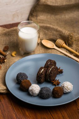 Şeker ve bisküvi mavi tabakta. Tatlılar kumaş. Bir bardak süt