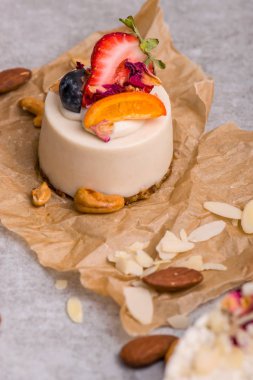 Çilek, portakal ve yaban mersini keki. Cupcake closeup fındık bir masada.