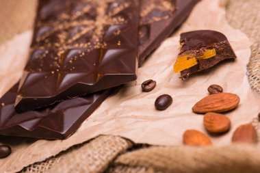 Hafif bir arka plan üzerinde siyah çikolata yakın çekim. Kahve, çikolata kağıt üzerinde.