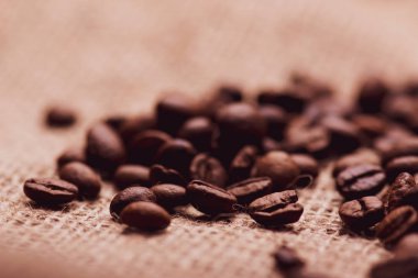 Cafe tasarımı, barlar ve kafeler için resimler. Çuval bezi ve kahverengi zemin closeup kahve taneleri.