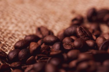 Cafe tasarımı, barlar ve kafeler için resimler. Çuval bezi ve kahverengi zemin closeup kahve taneleri.