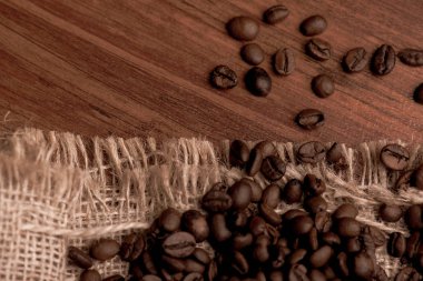 Cafe tasarımı, barlar ve kafeler için resimler. Çuval bezi ve kahverengi zemin closeup kahve taneleri.