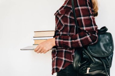 Bir tablet ve kitapların bir yığınına tutan bir kız elleri. Bilgi kavramı.