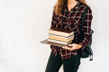 Bir tablet ve kitapların bir yığınına tutan bir kız elleri. Bilgi kavramı.