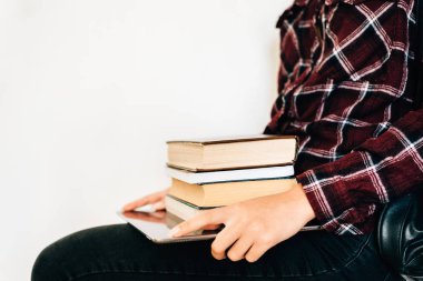 Bir tablet ve kitapların bir yığınına tutan bir kız elleri. Bilgi kavramı.