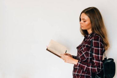 Kız ellerini ve gönüllülük ile kopya alanı beyaz arka plan üstünde sırt çantası kitap ile