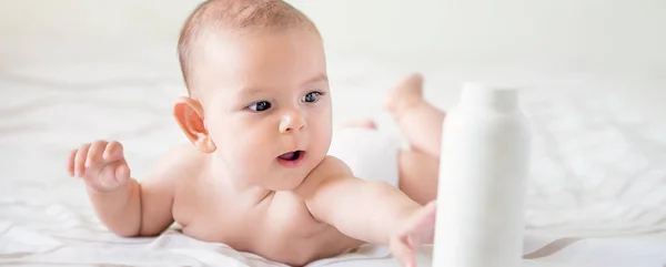 Hermoso Bebé Sosteniendo Biberón Cuidado Mano Loción Barriga Tiempo Cama — Foto de Stock