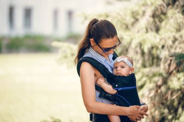 Küçük bebek kız ve annesi babywearing dışında yürüyüş ergo taşıyıcı kavramı