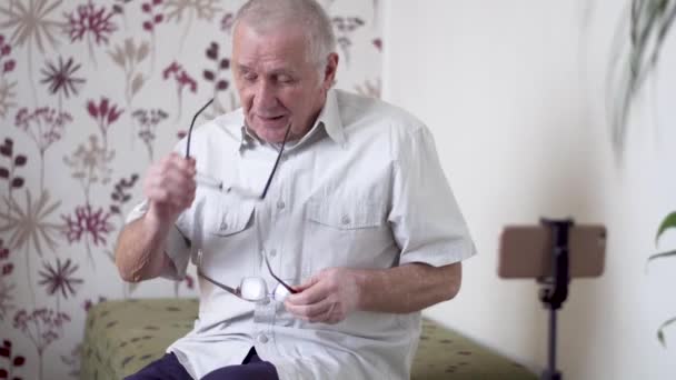 Модный пожилой человек делает видеоблог со смартфоном — стоковое видео