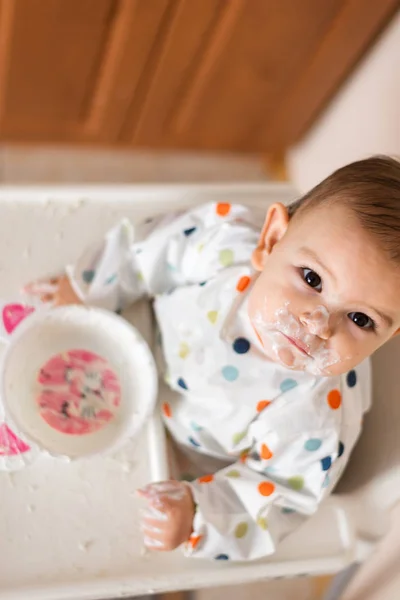 Un pequeño bebé comiendo su cena y haciendo un lío —  Fotos de Stock