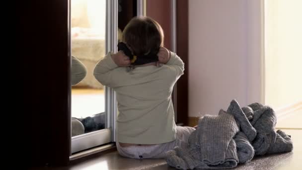 Una niña pequeña bebé en casa cerca del espejo disfrazándose, juego montessori independiente — Vídeo de stock