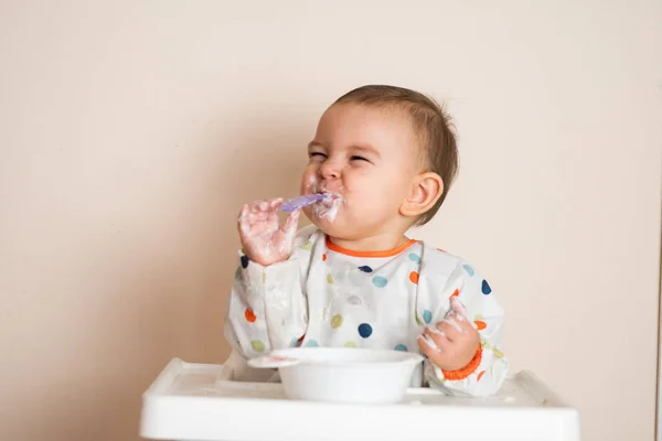Um bebezinho comendo seu jantar e fazendo uma bagunça — Fotografia de Stock