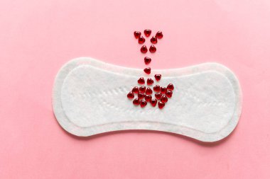 Feminine hygiene pad on a pink background. Concept of feminine hygiene during menstruation. top view. clipart