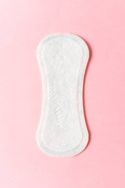 Pembe arka planda kadınsı hijyen yastığı. Adet sırasında kadın hijyeni kavramı. üst görünüm.