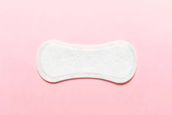 粉红色背景上的女性卫生垫。月经期间女性卫生的概念。顶部视图. — 图库照片