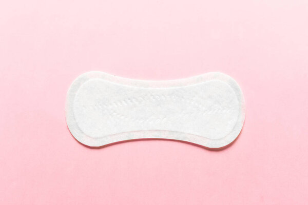Feminine hygiene pad on a pink background. Concept of feminine hygiene during menstruation. top view.